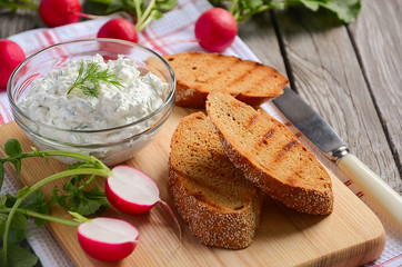 Cottage cheese cream with dill and garlic with toasts and radish.