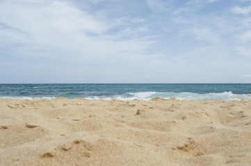 Fototapeta na wymiar Coastal landscape. Beach, sand and sea, with a blue sky with clouds. Top copyspace.