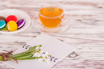 macaroon, a cup of tea and flowers on the table