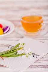 macaroon, a cup of tea and flowers on the table