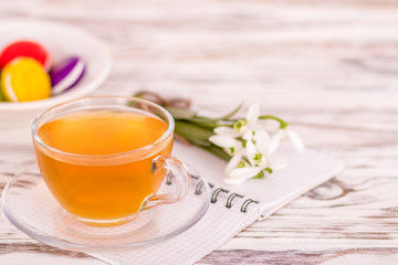 macaroon, a cup of tea and flowers on the table