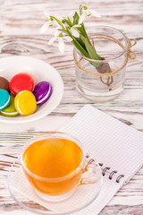 macaroon, a cup of tea and flowers on the table
