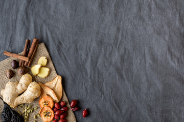 Spices and dried fruits on dark textile background