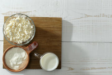 milk, sour cream, cottage cheese in cups on a table