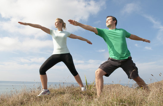 Mid adult couple exercising on cliff top, Thurlestone, Devon, UK