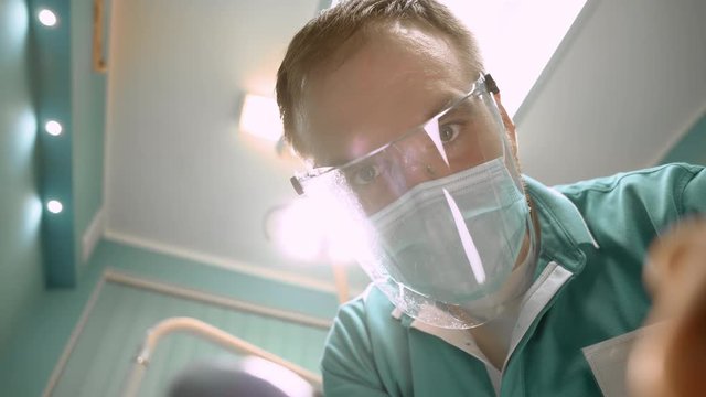 Dentist treating pretty patient. Slow motion. Close up