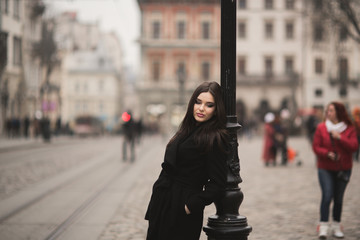 Beautiful brunette young woman posing on the street in old city