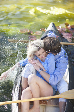 Young romantic couple fooling around in rowing boat