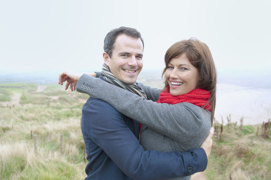 Couple hugging by coast