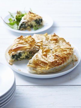 Still life of spanakopita with sliced portion