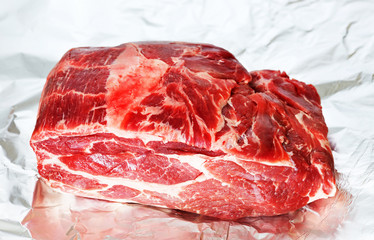 Piece of raw pork with salt on the foil. Preparation for cooking