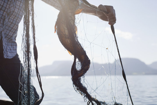 Person holding fish in net, Aure, Norway