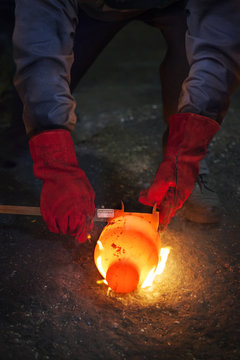 Checking diameter of still red hot flaming crank shaft with vernier