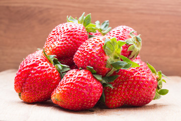 Red fresh strawberry fruits on wooden table.