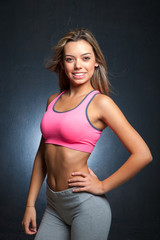 Fototapeta na wymiar Attractive female fitness model isolated on a black background