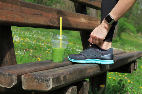 Woman Runner Drinking Green Vegetable Smoothie Resting After Workout. Sport, Fitness People Using Smart Watch