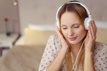 entspannte frau hört musik mit kopfhörern