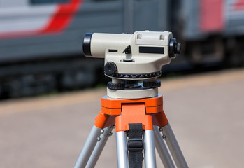 Geodetic equipment optical level mounted on tripod at the railwa