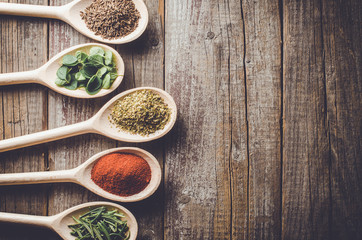 Aromatic herbs and spices on wooden spoons