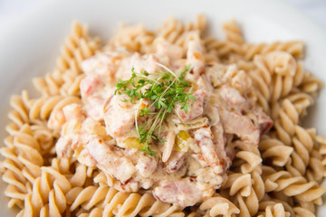Fusilli pasta with cream and bacon sauce decorated with cress