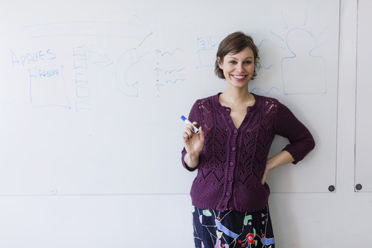 Portrait of young woman in front of whiteboard