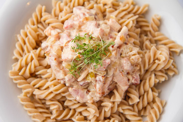 Fusilli pasta with cream and bacon sauce decorated with cress