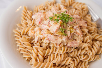 Fusilli pasta with cream and bacon sauce decorated with cress