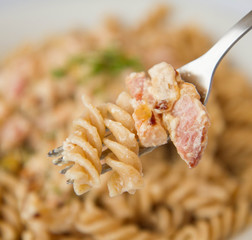 Fusilli pasta with cream and bacon sauce decorated with cress