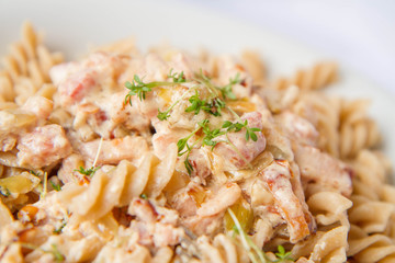 Fusilli pasta with cream and bacon sauce decorated with cress