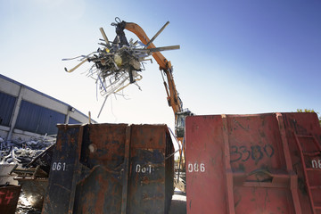 Grapple handler sorting and moving metals into scrap yard container