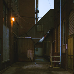Looking down an old industrial alley during twilight, filtered image. © jeffcampbell