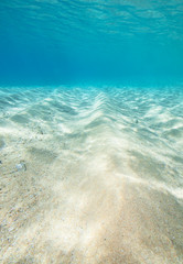 Fototapeta na wymiar Underwater shot of the sea sandy bottom at sunny day