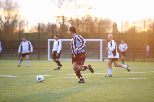Football players running after ball