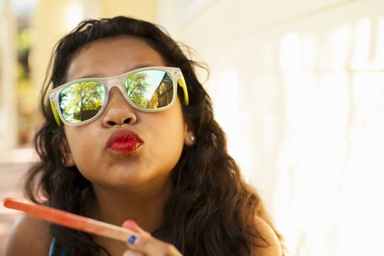 Portrait Of Girl With Red Lips And Ice Lolly Stick Pulling Face