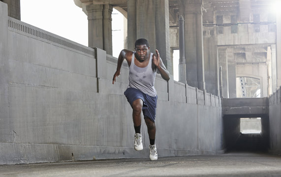Young man speed running over city bridge