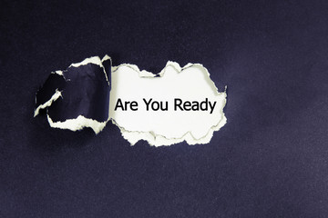 The question Are You Ready appearing behind torn paper