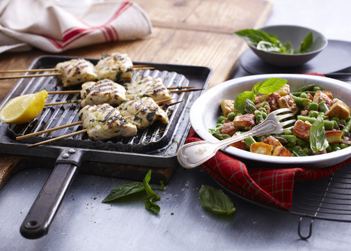 Chargrilled snapper skewers with lemon and bowl of salad