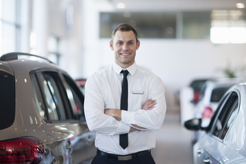 Portrait of smiling salesman in car dealership