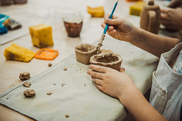 Child sculpts the product from raw clay