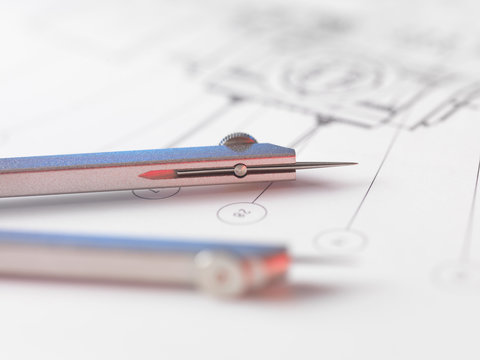 Dividers sitting on engineering drawing used in the measurement of design features