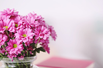 Beautiful flowers in vase on table in room