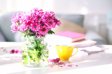 Beautiful flowers in vase on table in room