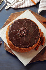 Tasty chocolate cake on color wooden background