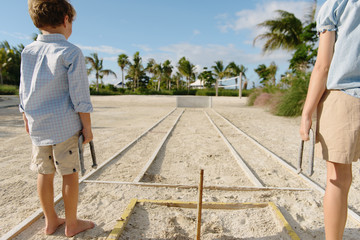 Sister and brother playing horseshoe game, Providenciales, Turks and Caicos Islands, Caribbean