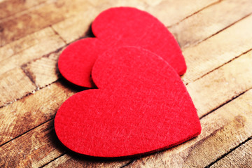 Obraz premium Red felt hearts on wooden background