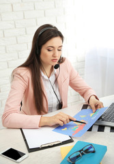 Young woman talking on headset in the office of travel company