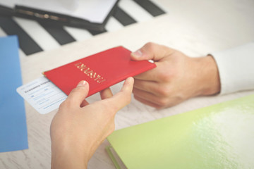 Agent giving passport and ticket to customer in the office of travel company