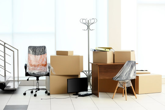 Moving cardboard boxes and personal belongings near stairs in office