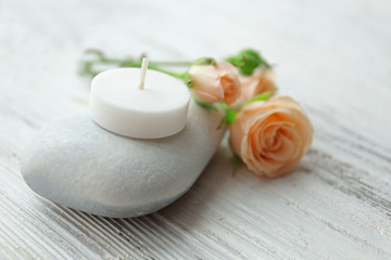 Obraz na płótnie Canvas Spa stones with beautiful flowers and candle on white wooden table