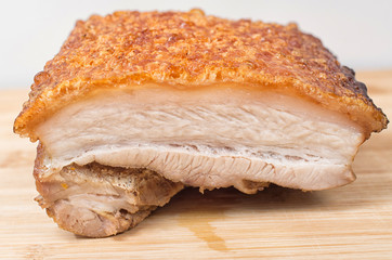 Close up view of a piece of Chinese roasted pork belly on wooden